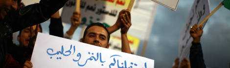 A crowd of demonstrators participating in a protest against the ongoing use of weapons by rebel militias inside Tripoli and accompanying atmosphere of lawlessness wave banners demanding disarmament and the creation of a national army. The newly-formed Libyan government is struggling to assert itself over the disparate power actors who emerged over the past year.