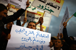 A crowd of demonstrators participating in a protest against the ongoing use of weapons by rebel militias inside Tripoli and accompanying atmosphere of lawlessness wave banners demanding disarmament and the creation of a national army. The newly-formed Libyan government is struggling to assert itself over the disparate power actors who emerged over the past year.