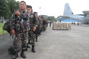 Philippine Army servicemembers stand alongside a pallet of bottled water as they prepare to board a U.S. Marine Corps KC-130J to support victims of Super Typhoon Haiyan at Villamor Air Base, Manila, Republic of the Philippines Nov. 11. Source: U.S. Marine Corps. (Photo by Lance Cpl. Stephen D. Himes/Released)