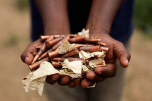 An ex-combatant holds up munitions in Attécoubé, Abidjan, Côte d'Ivoire. Source: UN Photo (Flickr) 