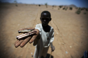 A child holds up bullets collected from the ground in Rounyn, a village about 15 kilometres from Shangel Tubaya, North Darfur. Most of the villages population has fled to camps for internally displaced because of heavy fighting between Government of Sudan and rebel forces.