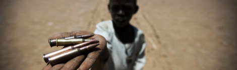 A child holds up bullets collected from the ground in Rounyn, a village about 15 kilometres from Shangel Tubaya, North Darfur. Most of the villages population has fled to camps for internally displaced because of heavy fighting between Government of Sudan and rebel forces.