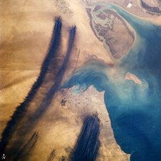 Black smoke plumes stream into the skies around Kuwait City in April 1991 five weeks after the fires were set. Credit: NASA's Earth Observator