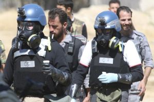 UN chemical weapons experts wearing gas masks carry samples from one of the sites of an alleged chemical weapons attack in the Ain Tarma neighbourhood of Damascus. Source: 
