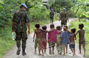 Members of the United Nations Transitional Administration in East Timor (UNTAET) Portuguese contingent are accompanied by a group of local children as they conduct a security patrol in the Becora district of Dili. 1/Mar/2000. Dili, East Timor. UN Photo/Eskinder Debebe. www.unmultimedia.org/photo/